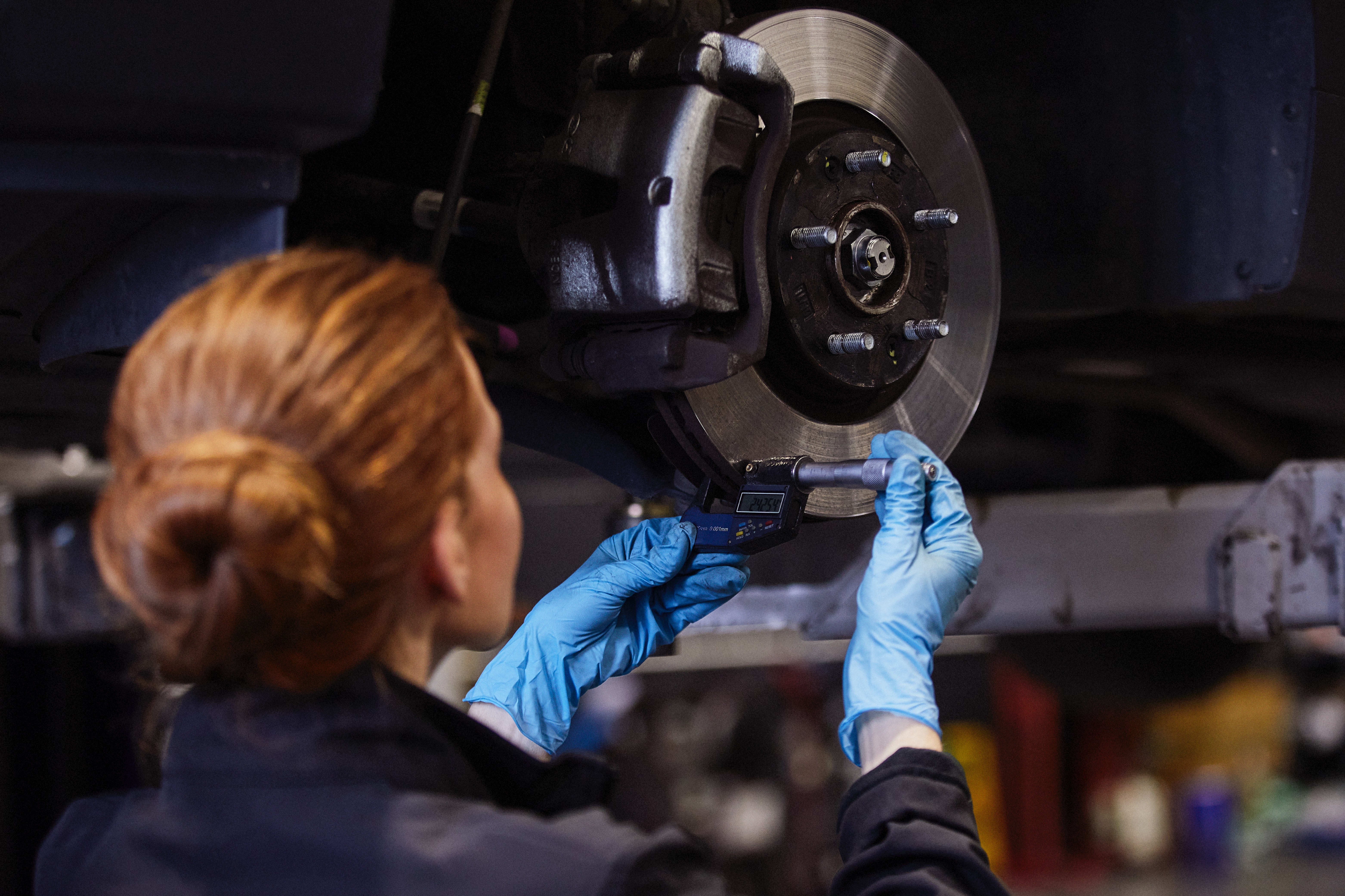 An image of a mechanic fixing breaks on a car